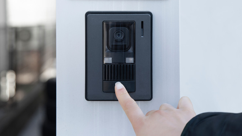 hand pushing video doorbell