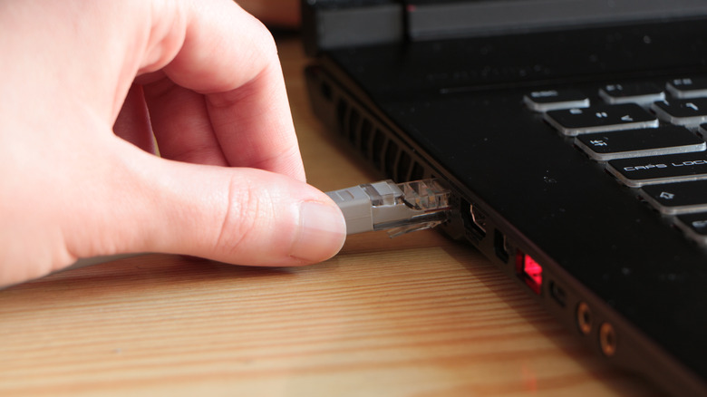 hand plugging in ethernet cable