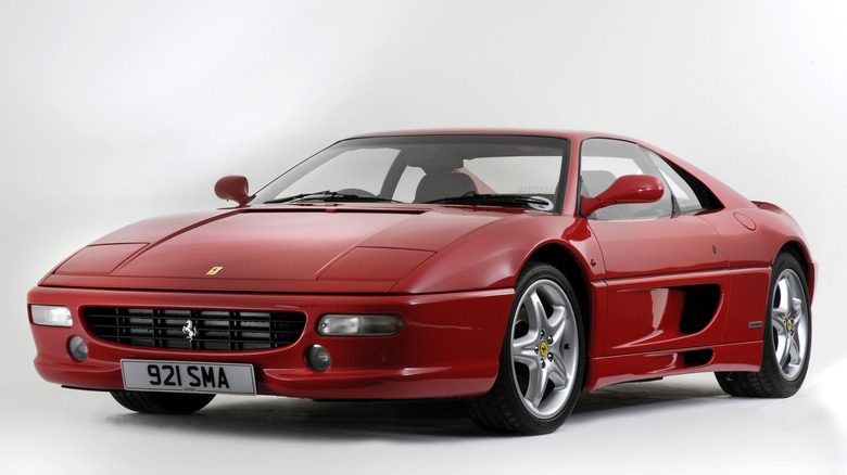 A red Ferrari F355, front 3/4 view, white background, studio shot