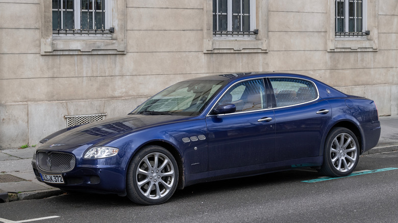 A blue fifth generation Maserati Quattroporte, street parked, front 3/4 view