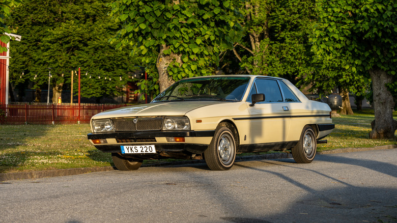 A street parked Lancia Gamma Coupe in beige, front 3/4 view