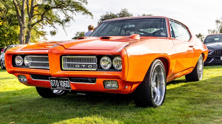 Orange Pontiac GTO in an open car show