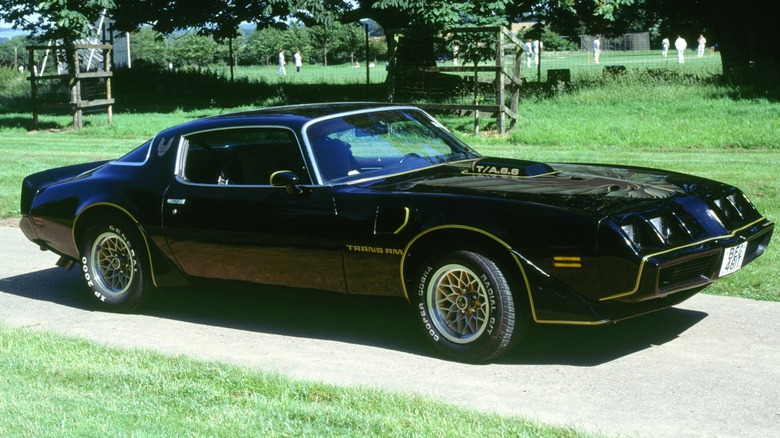 Black Pontiac Firebird Trans Am parked on a grassy area