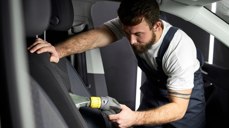 Close up of technician vaccumming the car seat