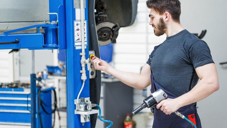 Technician elevating a car lift