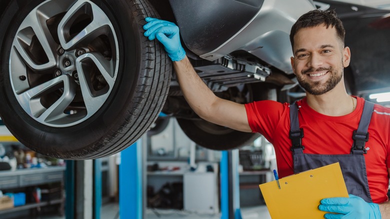 Auto technician inspecting tire