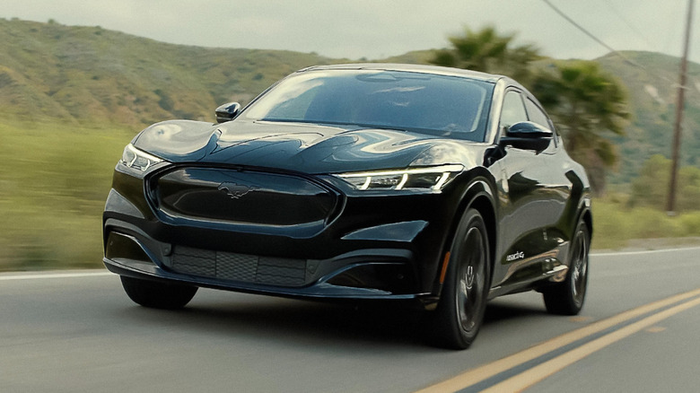 The Ford Mustang Mach-E in all black on the move, front 3/4 view