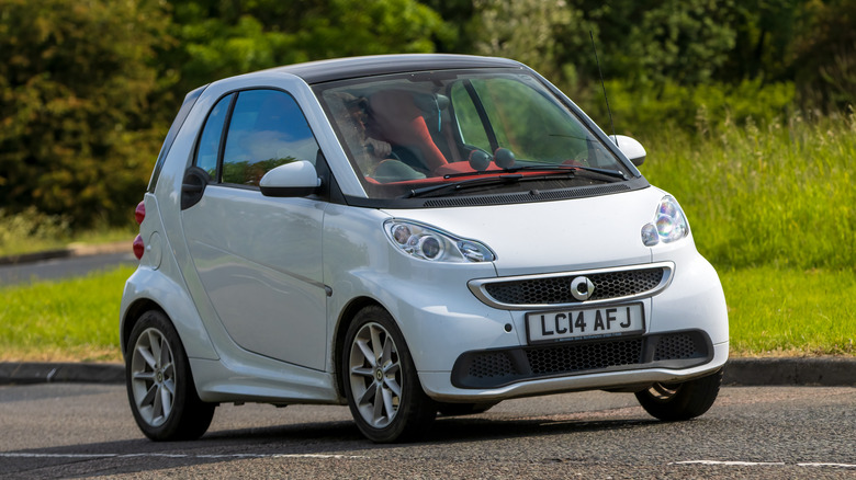 A white 451 Smart Fortwo on the move, front 3/4 view