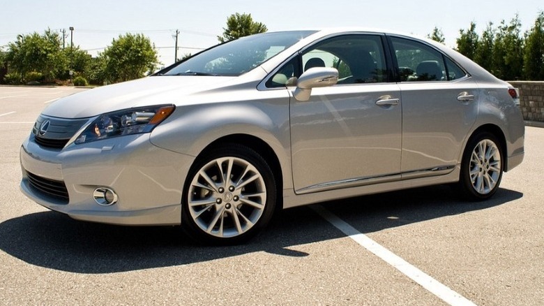 Lexus HS 250h parked on a pavement with trees in the background