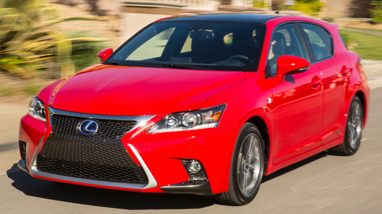 Lexus CT200h driving down a road next to residential buildings