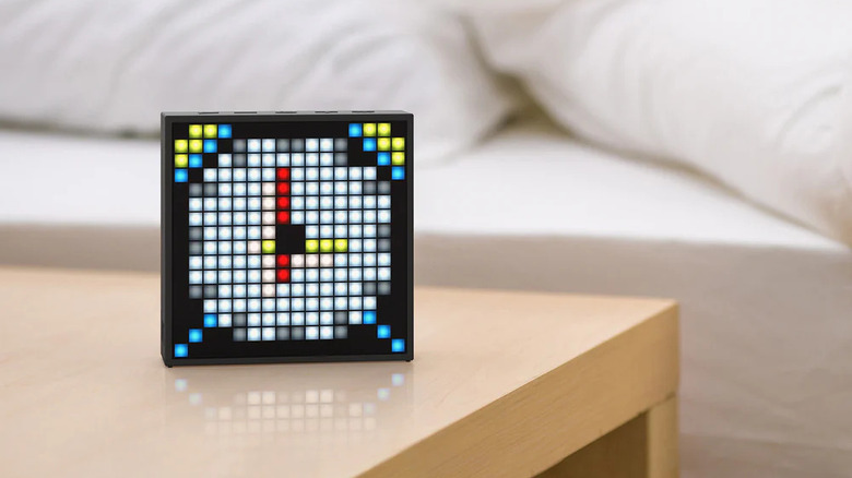 A Divoom TimeBox Evo pixel art display showing an alarm clock