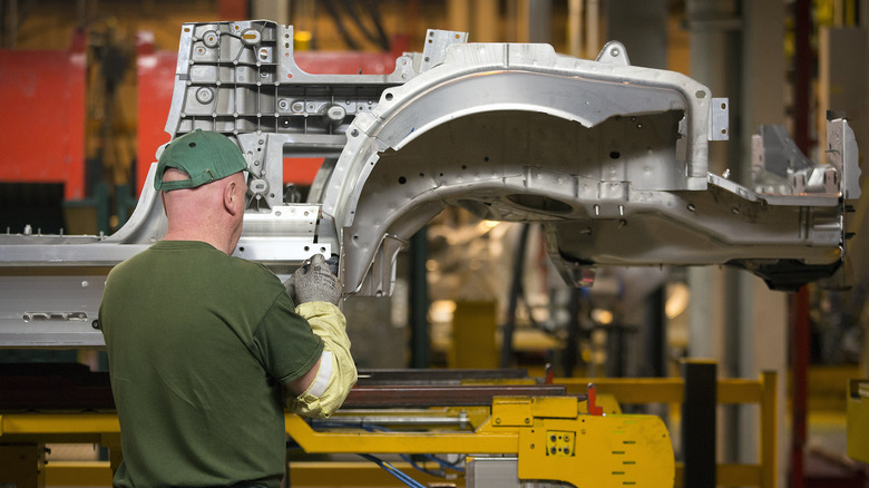 Employee works on Jaguar chassis at Castle Bromwich plant