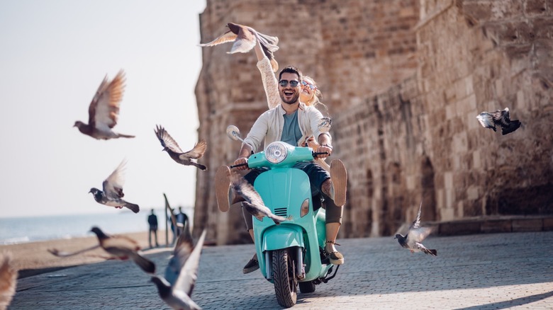 Couple riding scooter