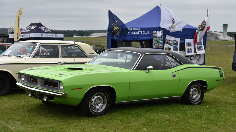 A 1970 Plymouth Cuda in green, front 3/4 view, open air car show