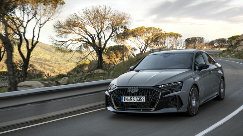 Silver Audi RS 3 driving down winding road