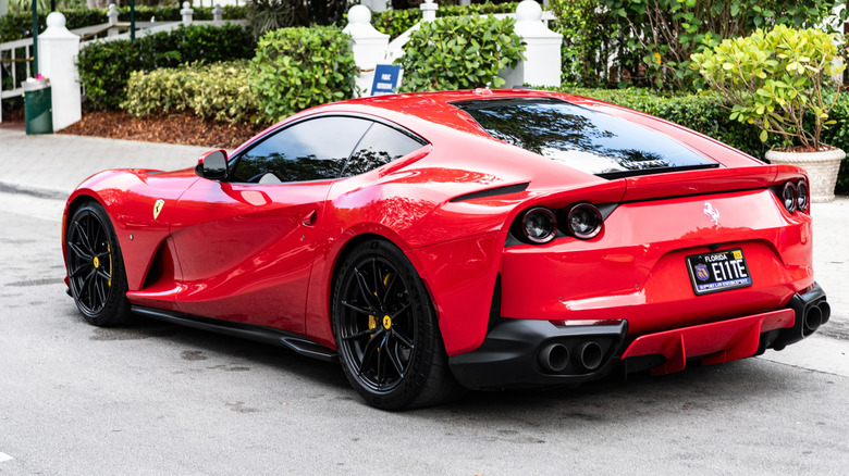 Red Ferrari 812 parked in fancy neighborhood