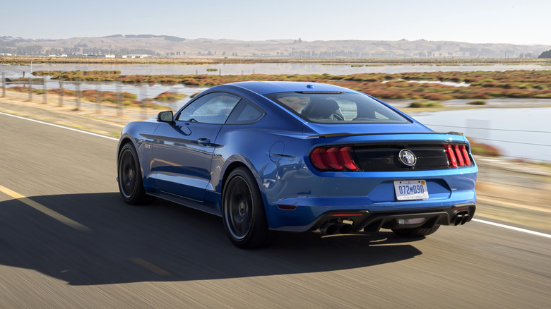 Blue Mustang driving fast near lake