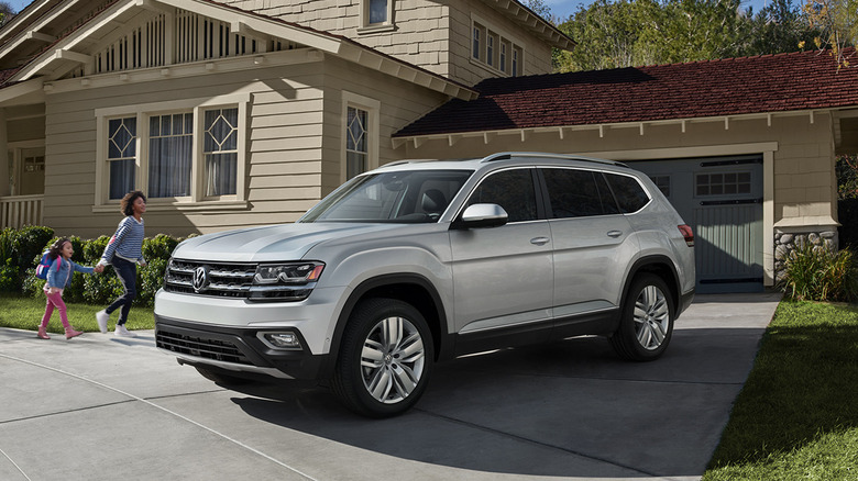 A silver Volkswagen Atlas parked on a driveway, front 3/4 view