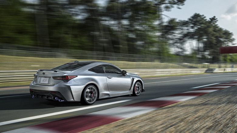 2025 Lexus RC F Final Edition driving at speed on track rear 3/4 view