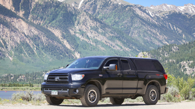 An orange Toyota Tundra TRD with a mountain backdrop