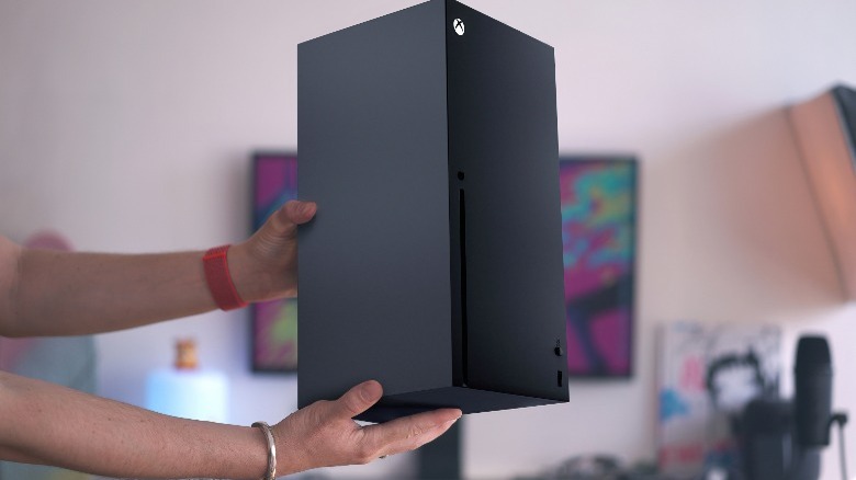 Someone holding an Xbox Series X console
