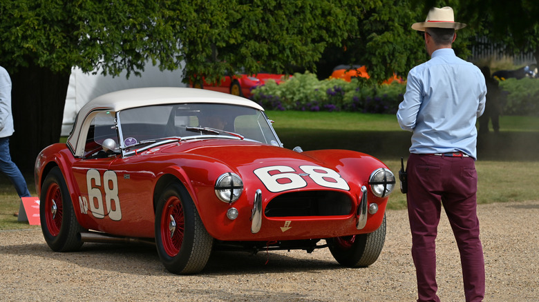 person looking at vintage Shelby vehicle on display