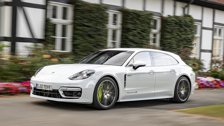 The Porsche Panamera Sport Turismo in white driving, front 3/4 view