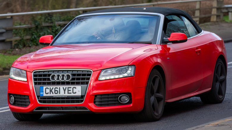 Red 2011 Audi A5 driving on a country road