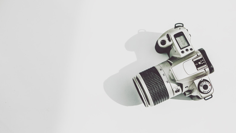 A white DSLR camera on a gray background.