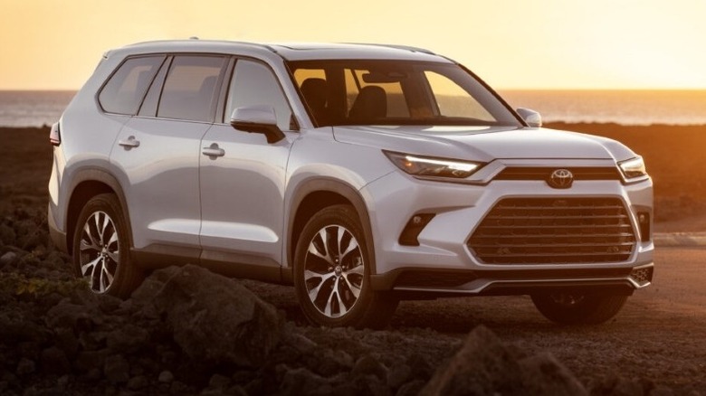 2024 Toyota Grand Highlander Hybrid Max Limited parked off-road with setting sun in the background