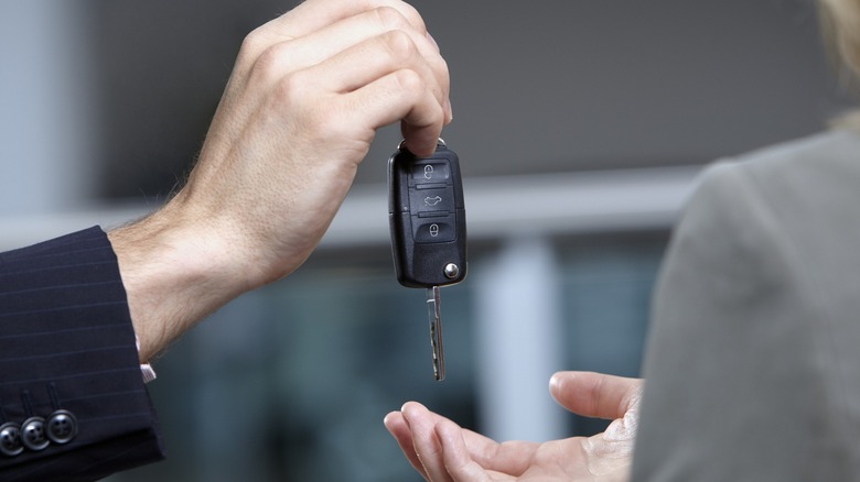 Two people exchanging a car key