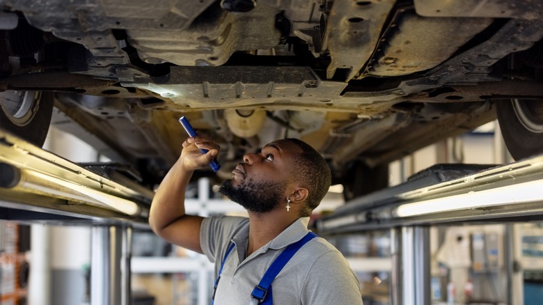 Mechanic inspecting vehicle