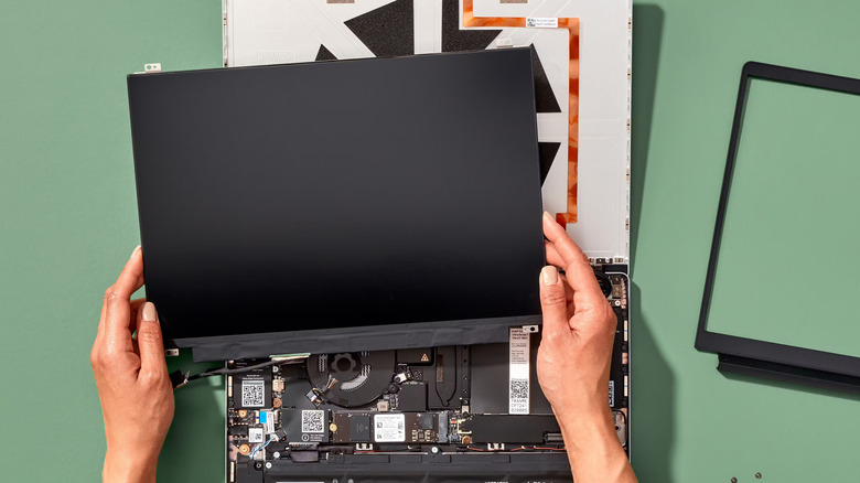 Woman holds the display of an opened Framework laptop