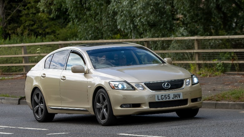 a beige Lexus GS300 driving down a road