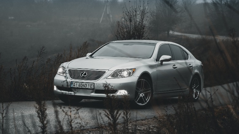 a grey Lexus driving down a road