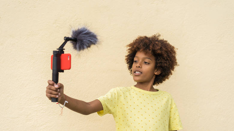 Child using iPhone with microphone