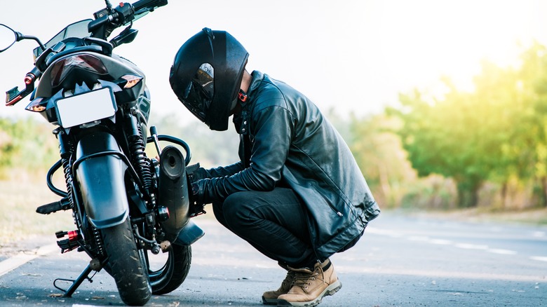 rider working on motorcycle