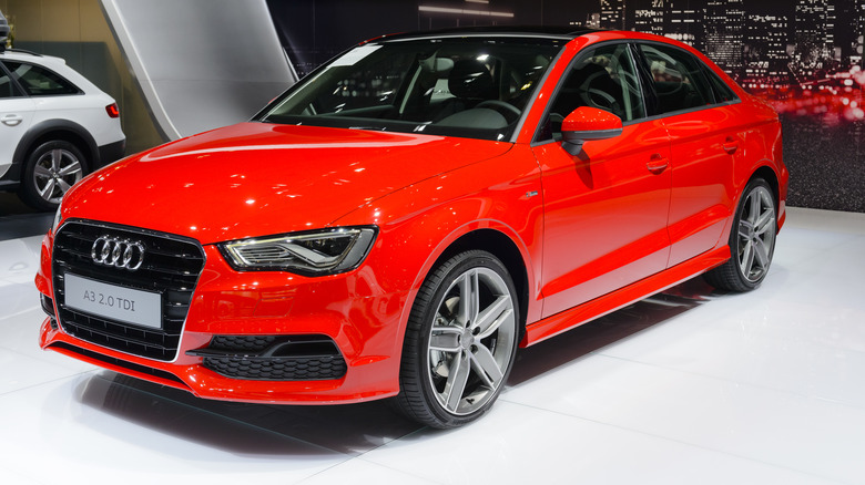 The Audi A3 Sedan in red at an auto show, front 3/4 view