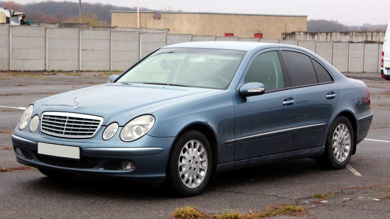 A W211 Mercedes E-Class in dark blue, front 3/4 view