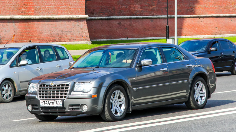 A gray Chrysler 300C on the move in traffic, front 3/4 view