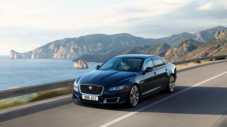 A Jaguar XJ (X351) on the move on a mountain road, front 3/4 view