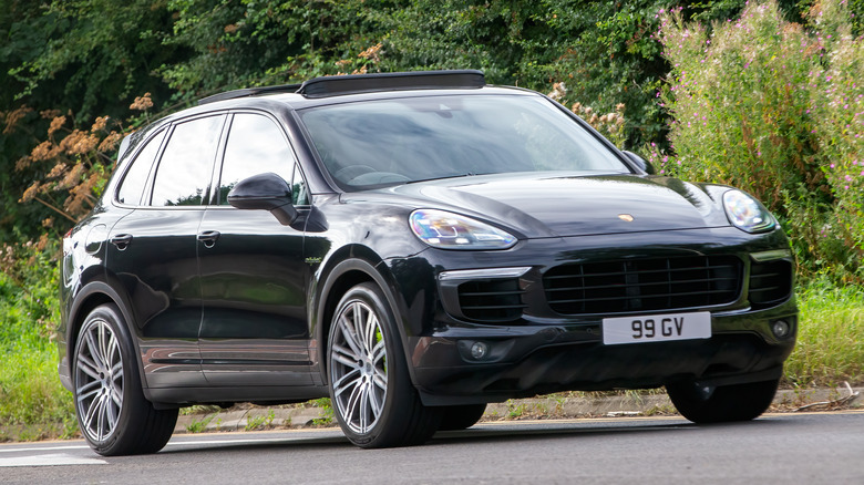 A second generation Porsche Cayenne on the move in black, front 3/4 view