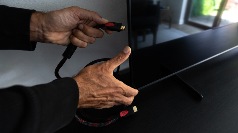 person plugging in hdmi