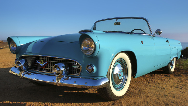 Teal Ford Thunderbird parked in field