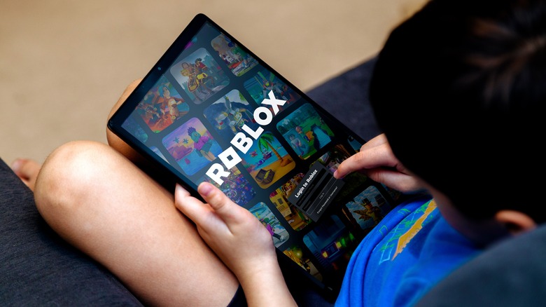 Child holiding Roblox screen