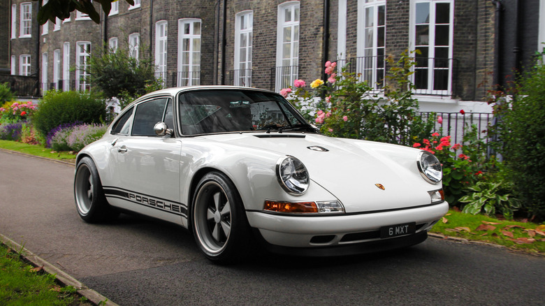 A Singer Porsche 911 in white with a black stripe, front 3/4 view