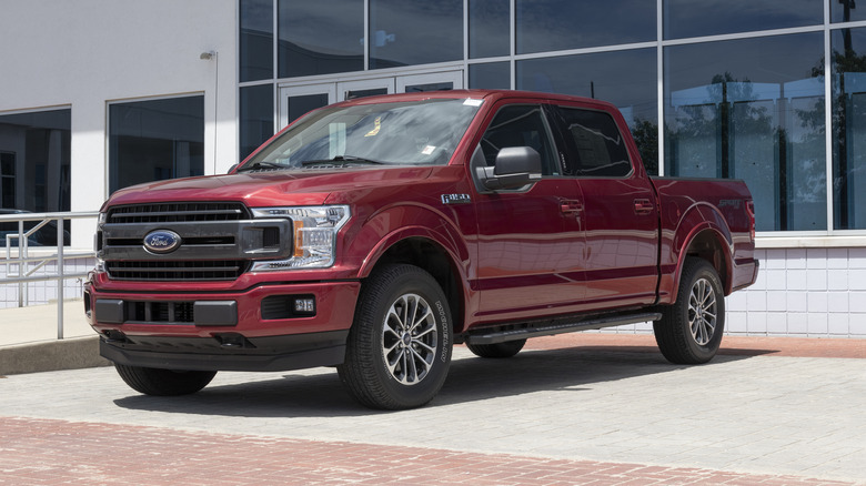 A red Ford F-150 on a dealership lot