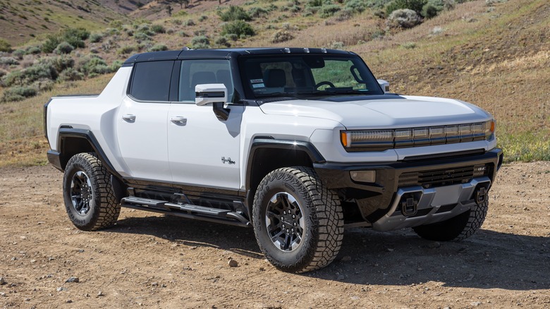 A white Hummer EV on a dirt road