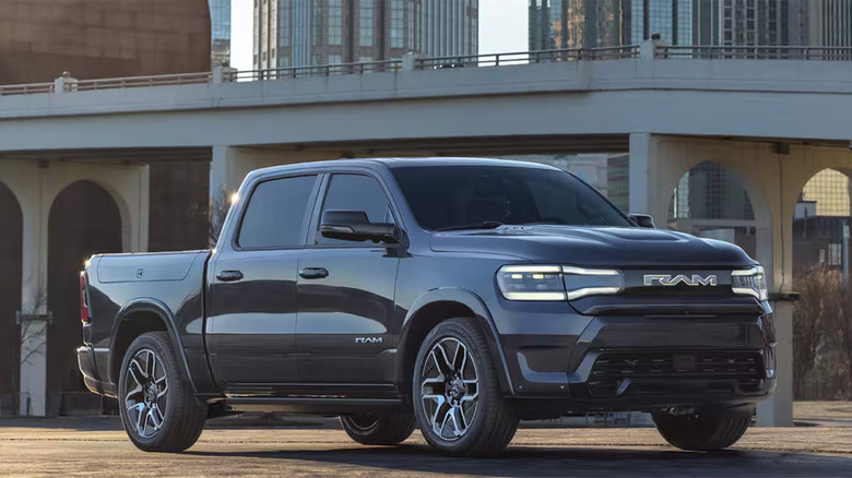 A black Ram 1500 REV parked by a bridge