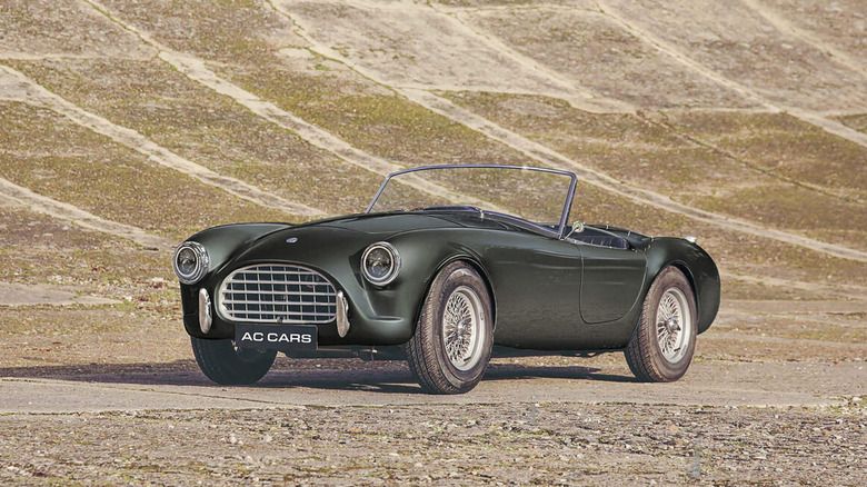 The AC Ace restomod parked on what appears to be an old concrete racing track.